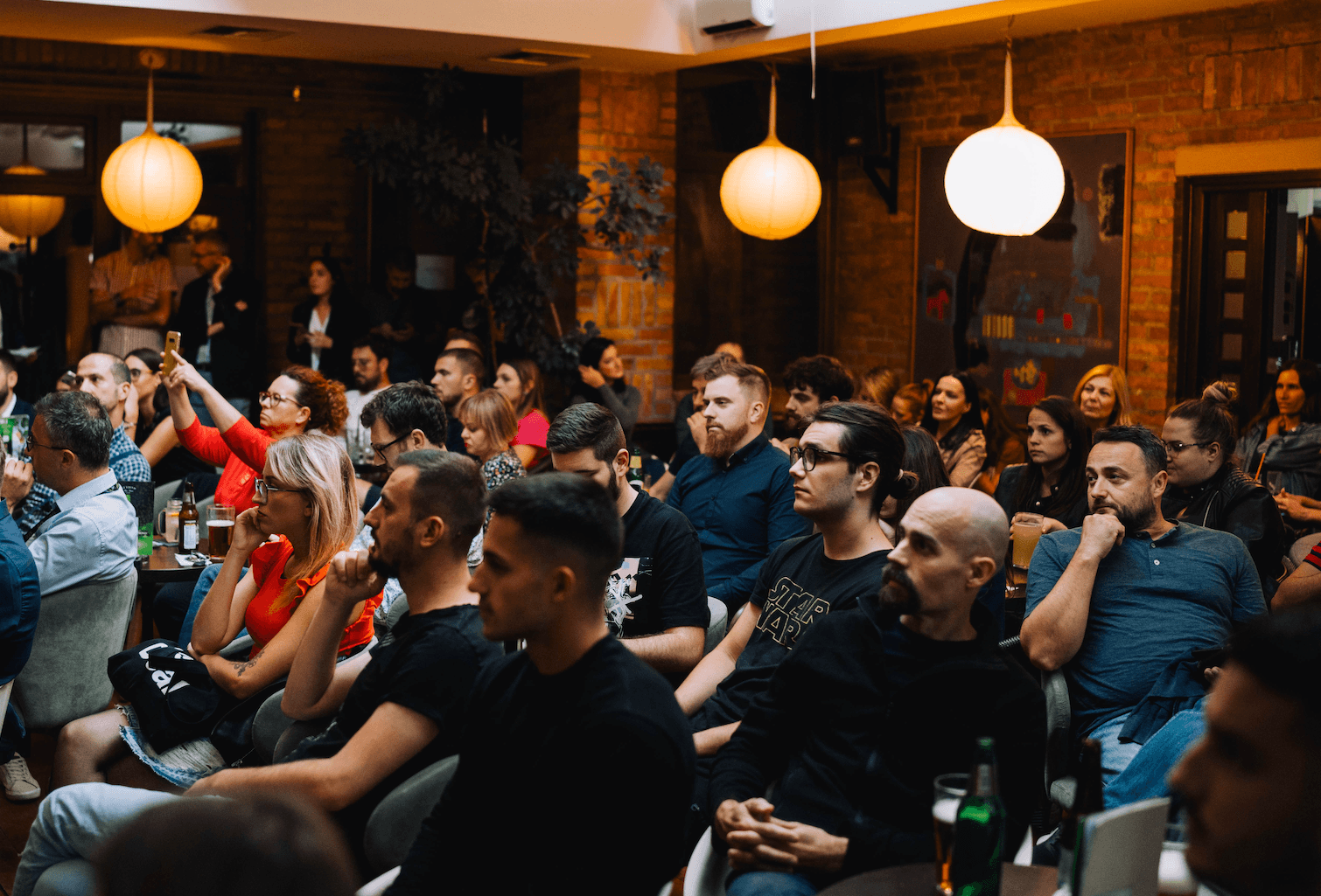 Three people listening to a lecture